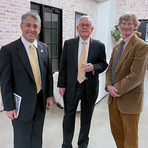 Three men standing together in suits.