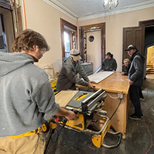 - Sussex County Community College students in the Building Construction Technology program are getting first-hand experience by working on an important historical project.   The students are participating in a restoration of the 1858 Horton Mansion on the College’s main campus. The entire project, which started in September, is expected to take two to three years and will be achieved in multiple phases.  The four-story Mansion was built by John Horton, a county native, who made his fortune in saddlery and harness making. He died shortly after it was built, but it remained in the family until 1921 when it was sold to several members of the Galente family, who quickly sold the property to the Missionary Society of the Salesian Congregation.   After many years as Don Bosco Prep, training priests and educators, the county purchased the property in 1984, including the Gothic Revival mansion which is a centerpiece of the campus, standing in contrast to the red brick buildings surrounding it. County residents associate SCCC with the Horton Mansion, even if they don’t know its name.  The College faculty and about ten students are working to bring the Horton Mansion back to its former glory. The project gives students real-life, real-time construction experience and allows them to work effectively with tools and materials necessary for the trade.  The students are doing "a little bit of everything from framing, sheet rocking, and carpentry,” according to adjunct instructor Frank Semplenski. The added bonus is that it is a historic building, noting, “They love this project and are learning many new skills. They look forward to getting into the building to work.”   Semplenski, who also owns his own company, FMS Construction, added "It's just a beautiful building," and commented on the opportunity for his students, "You are not always going to get the new jobs."  College officials believe it is important for the students to gain experience in this type of restoration. Two of the goals of the Building Construction Option, which results in an associate of applied science degree, are to demonstrate effective problem-solving skills based on knowledge and practice and understand, integrate, and apply construction knowledge and skills professionally. The Horton Mansion project is a perfect way to meet these goals.  Building Construction is only one of several technical programs under the AAS degree programs. Others include baking and pastry, cosmetology, culinary arts, diesel service, electrical linesworker, machine tool, optics, robotics, technical theater, and welding. All provide opportunities for students to learn career skills to help them enter the workforce upon graduation.  For more information about the Building Construction or other technical programs, visit www.sussex.edu/apply Registration is now open for the spring semester, and classes start on January 23rd.   Pictured: SCCC Students in the Building Construction Technology program are instructed by their professor on the proper use of the equipment.