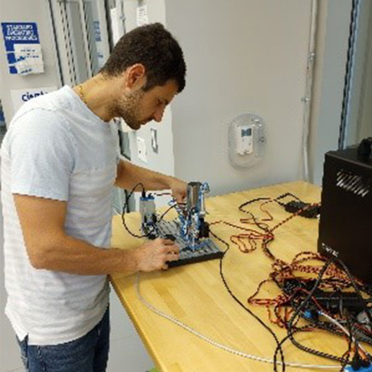 Man in white tshirt working on a robotics project
