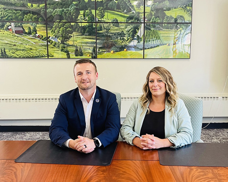 A professional Man and Woman seated at a conference table.