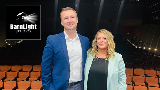 A professional man and woman stand on stage.